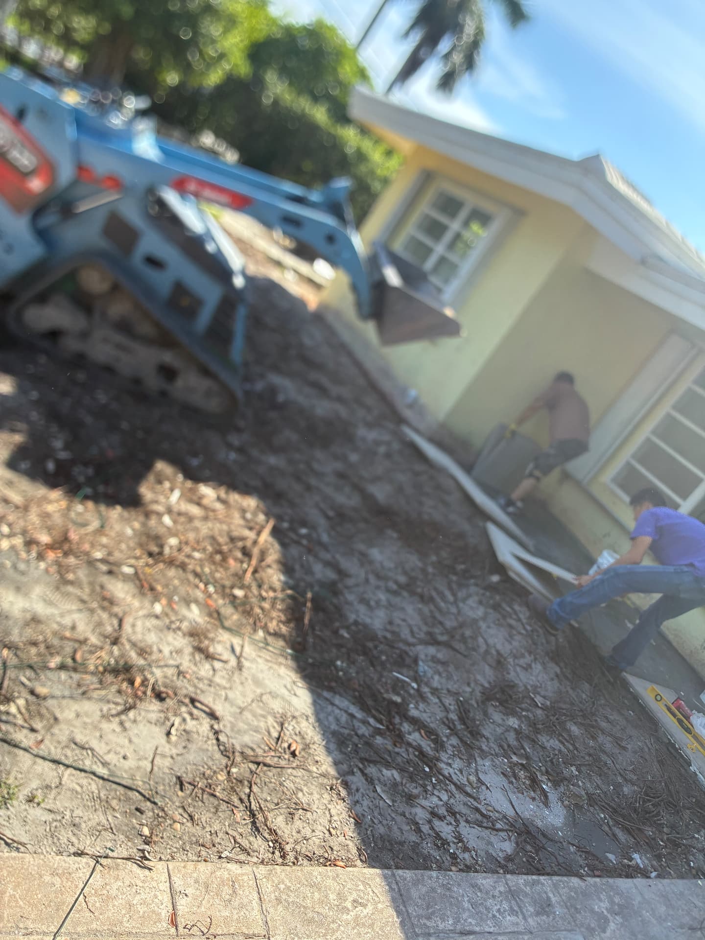 Crew setting pavers near the slab foundation — land grading and concrete slab prep by All Out Rubbish in Palm Beach County, Florida