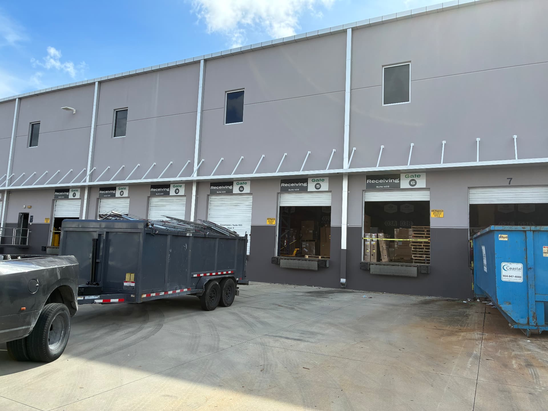 All Out Rubbish dump trailer loaded with dismantled warehouse shelving and pallet racking at a commercial loading dock for scrap metal recycling