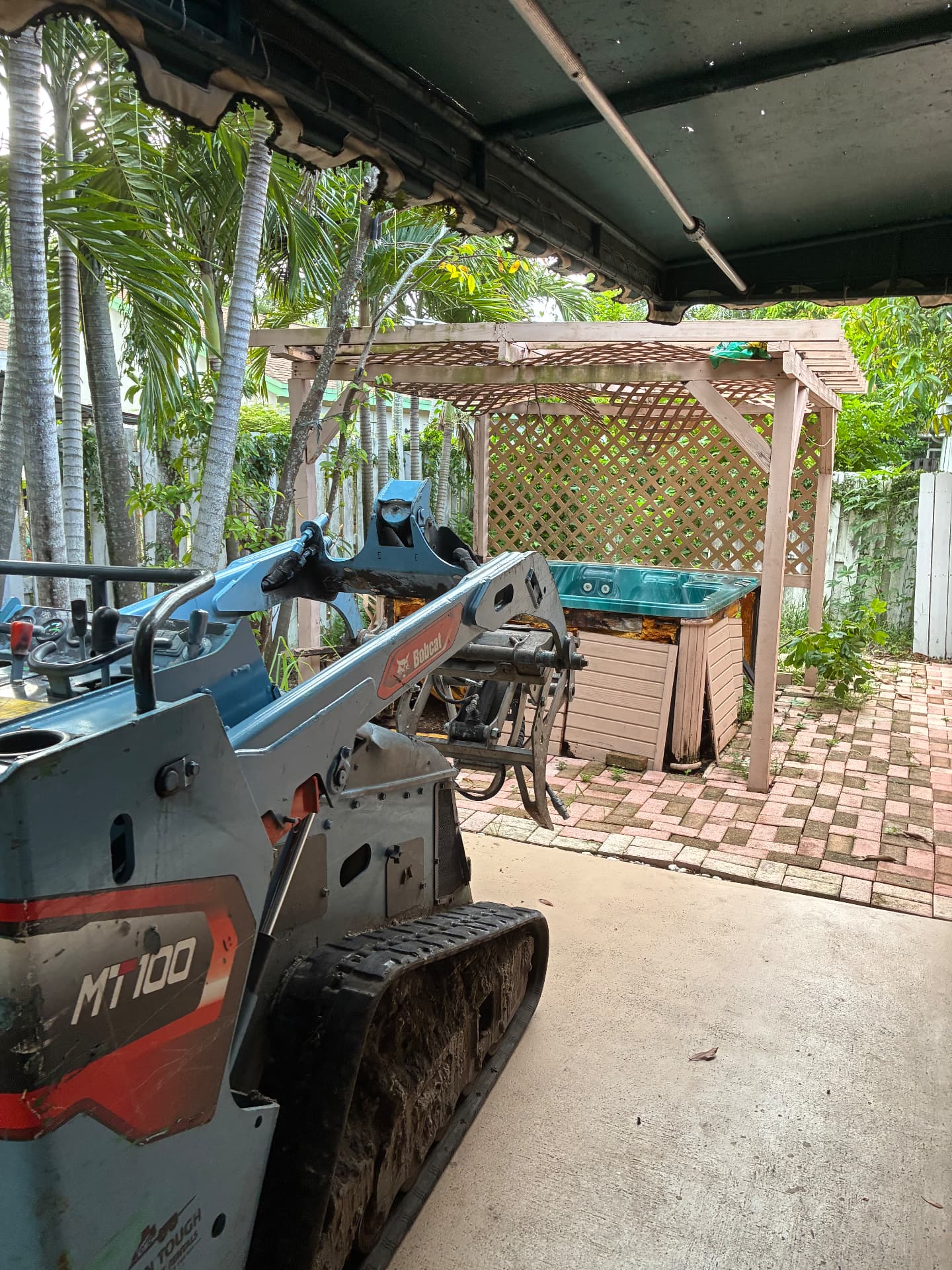 Our Bobcat MT100 mini track loader on the job — hot tub removal by All Out Rubbish in Palm Beach County, Florida