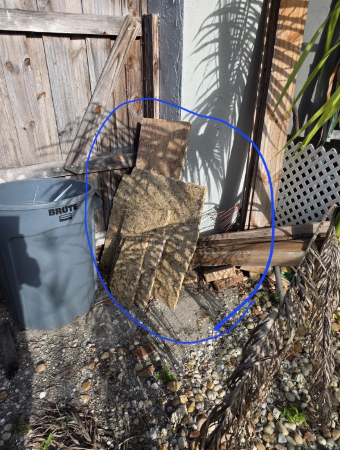 Before junk removal: granite slabs, white plastic lattice and loose bricks staged for pickup by All Out Rubbish in Palm Beach County, Florida