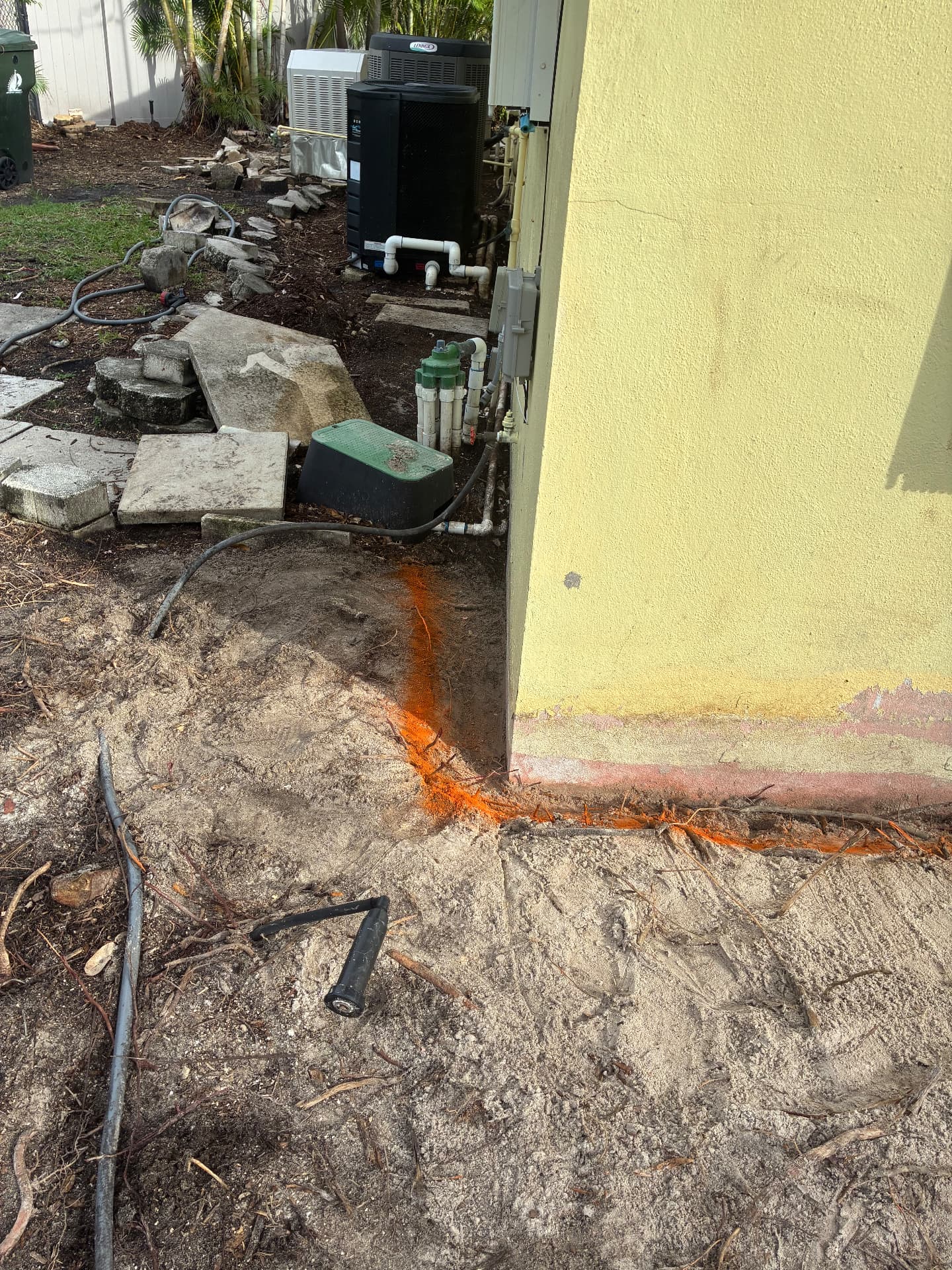 Utility line marked, roots exposed for concrete slab prep — land grading and concrete slab prep by All Out Rubbish in Palm Beach County, Florida