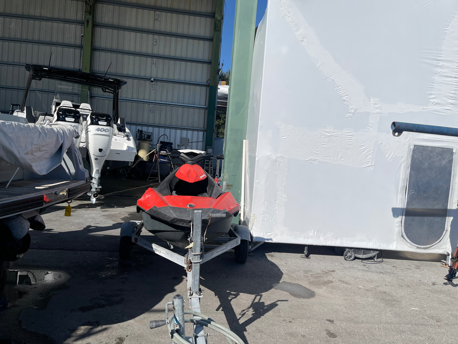 Red and black jet ski on a trailer at a South Florida boat marina, ready for All Out Rubbish to remove